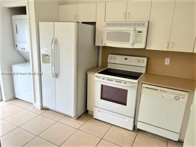 a kitchen with granite countertop white cabinets and white appliances