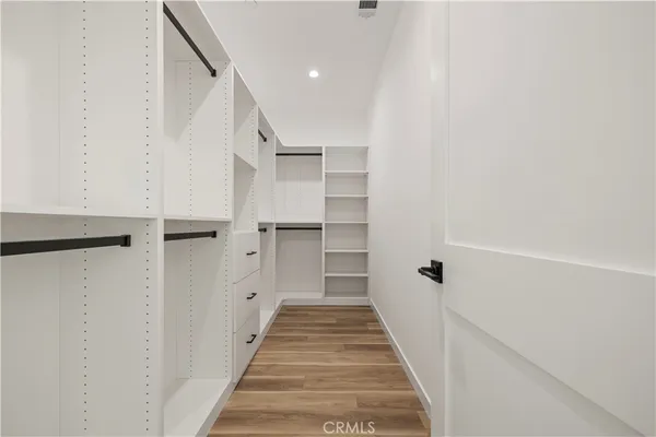 a view of a hallway with wooden floor and entryway