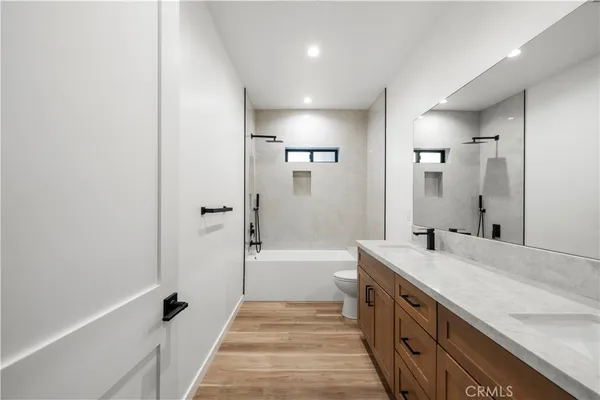 a spacious bathroom with a double vanity sink a mirror and a bathtub