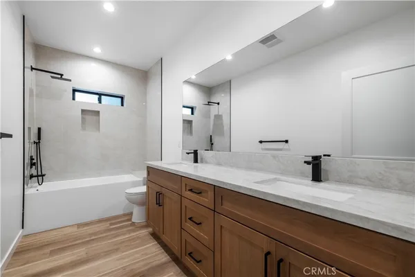 a bathroom with a tub sink toilet and a mirror