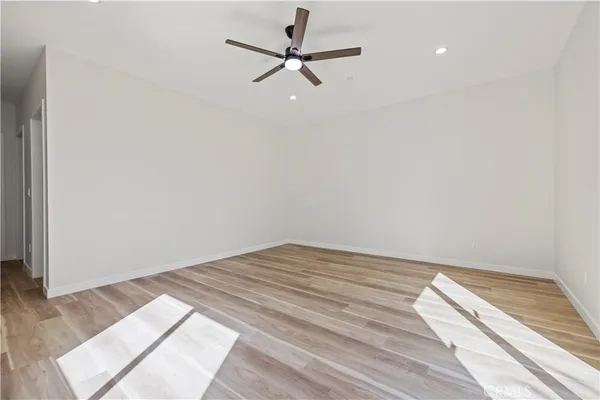 a view of a room with wooden floor and a ceiling fan