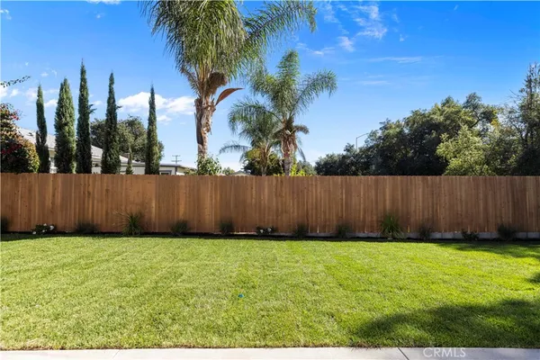 a view of a yard with wooden fence