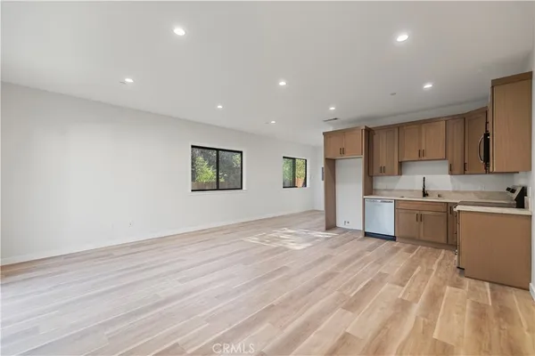 a view of kitchen with granite countertop cabinets and refrigerator