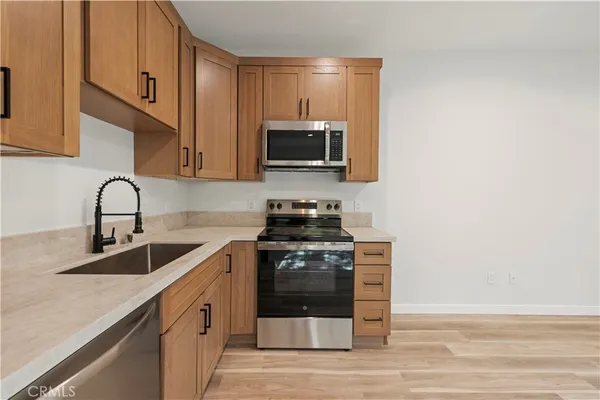 a kitchen with stainless steel appliances granite countertop a stove a microwave and a sink