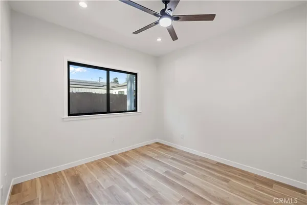 a view of empty room with window and ceiling fan