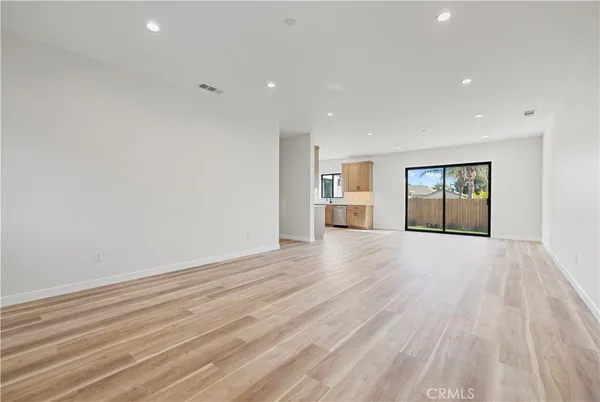 a view of empty room with wooden floor and windows