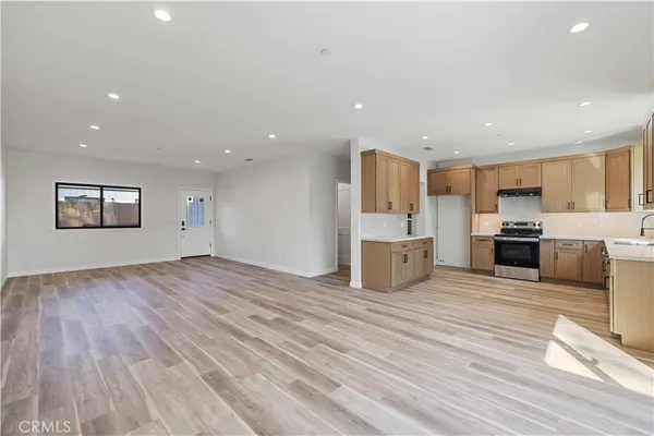 a view of a kitchen with a sink and dishwasher a refrigerator with wooden floor