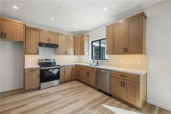 a kitchen with a sink stove top oven and cabinets