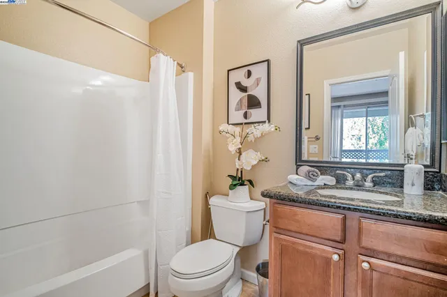 a bathroom with a granite countertop sink toilet and shower