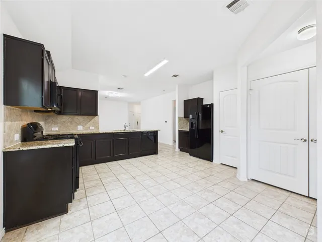 a kitchen with a stove a refrigerator and cabinets