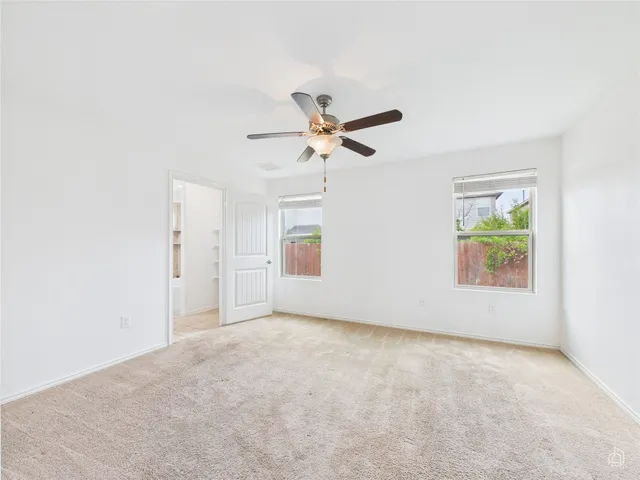 a view of a room with a ceiling fan and a window