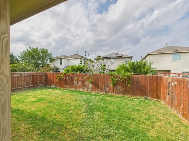 a backyard of a house with table and chairs