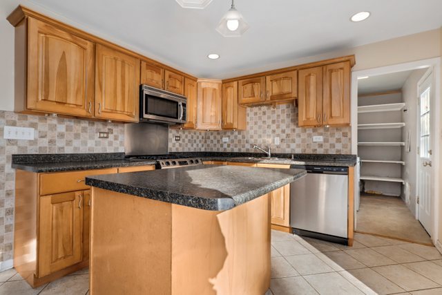 307 Oakwood Road Vernon Hills, IL 60061 - Photo 11 of 28 a kitchen with stainless steel appliances granite countertop a stove a sink and a microwave