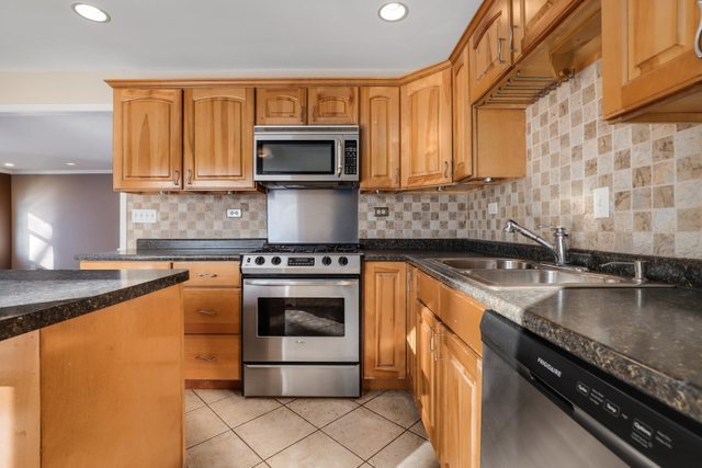 307 Oakwood Road Vernon Hills, IL 60061 - Photo 16 of 28 a kitchen with stainless steel appliances granite countertop a sink stove and microwave