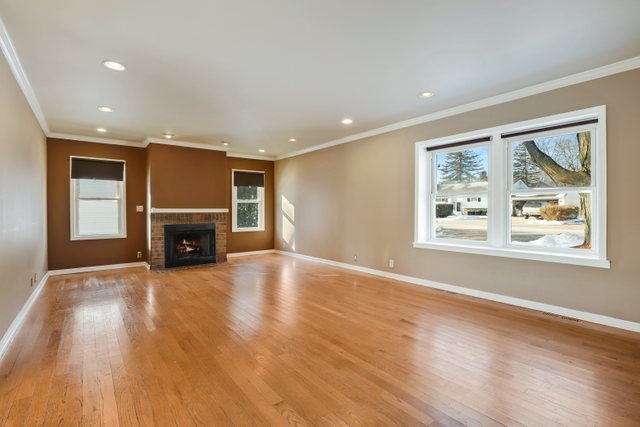 307 Oakwood Road Vernon Hills, IL 60061 - Photo 3 of 28 an empty room with windows fireplace and wooden floor
