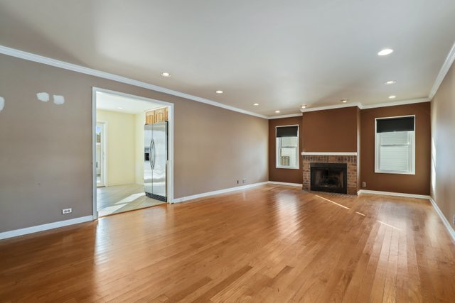 307 Oakwood Road Vernon Hills, IL 60061 - Photo 8 of 28 a view of an empty room with wooden floor fireplace and a window