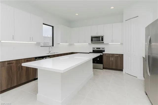 a kitchen with stainless steel appliances a sink stove and refrigerator