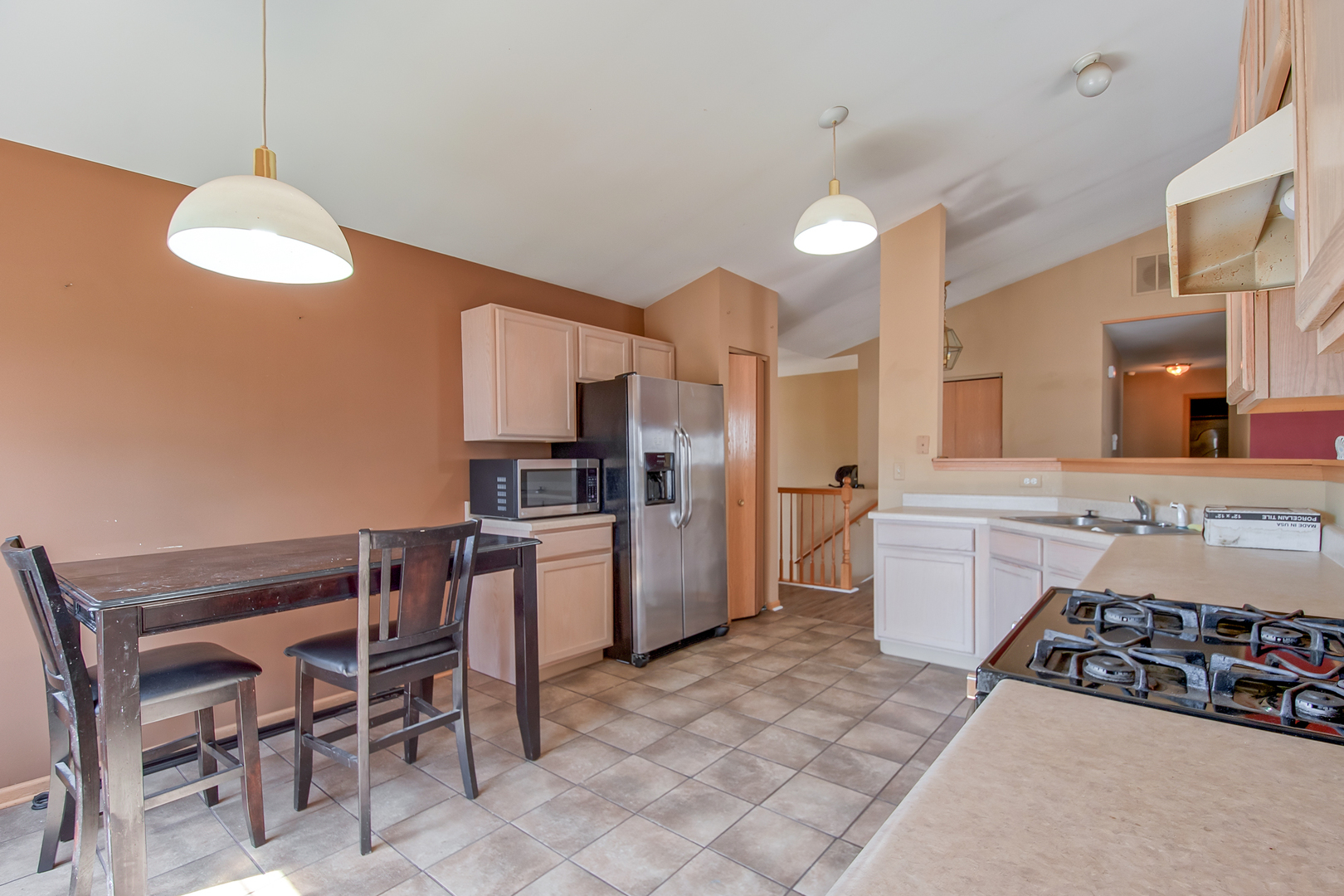 545 North Fox Trail Round Lake, IL 60073 - Photo 3 of 15 a kitchen with refrigerator a stove a sink and chairs