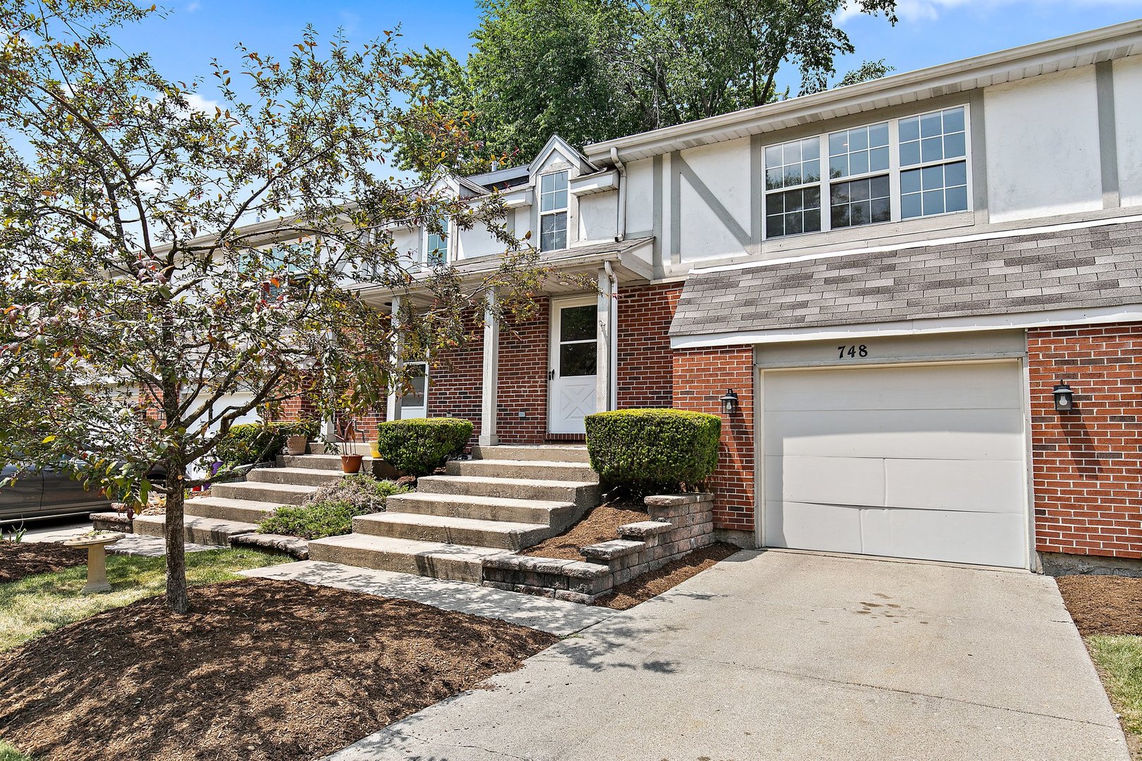a front view of a house with a yard and a garage
