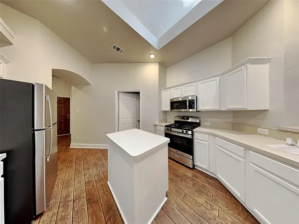 a kitchen with granite countertop a sink stove and refrigerator