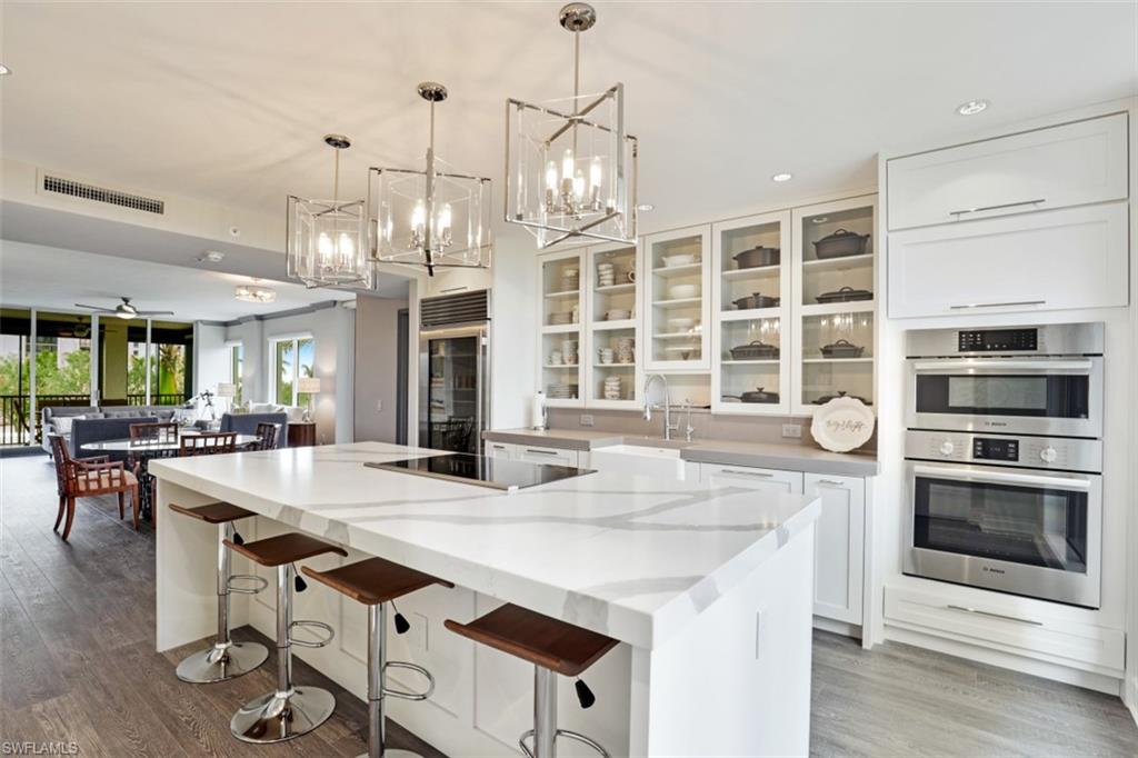 8720 Bay Colony Drive, Unit 304 Naples, FL 34108 - Photo 1 of 18 a kitchen with stainless steel appliances granite countertop a stove and a wooden floors