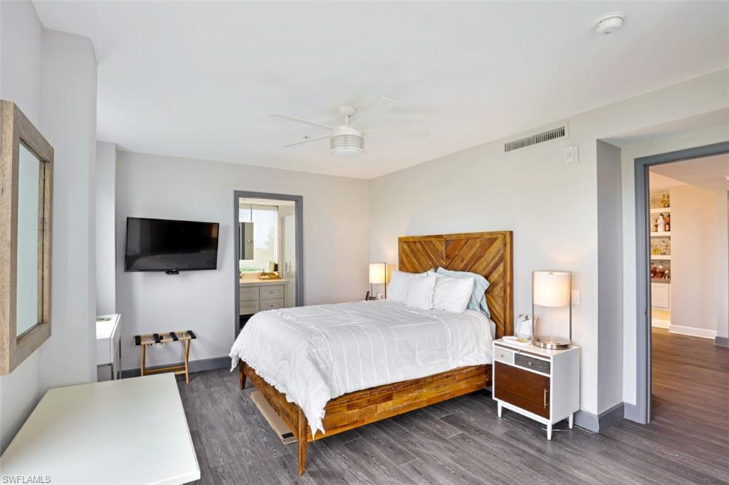 8720 Bay Colony Drive, Unit 304 Naples, FL 34108 - Photo 12 of 18 a bedroom with a bed and a flat screen tv