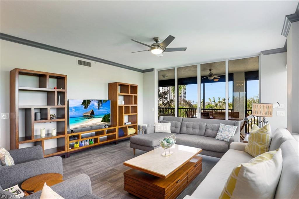 8720 Bay Colony Drive, Unit 304 Naples, FL 34108 - Photo 5 of 18 a living room with furniture and a flat screen tv