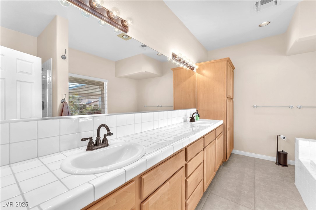 2251 Thoroughbred Road Henderson, NV 89002 - Photo 31 of 60 Full bathroom with tile patterned floors, double vanity, visible vents, and a sink