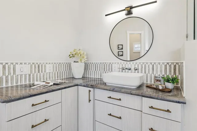 a bathroom with a granite countertop sink and a mirror