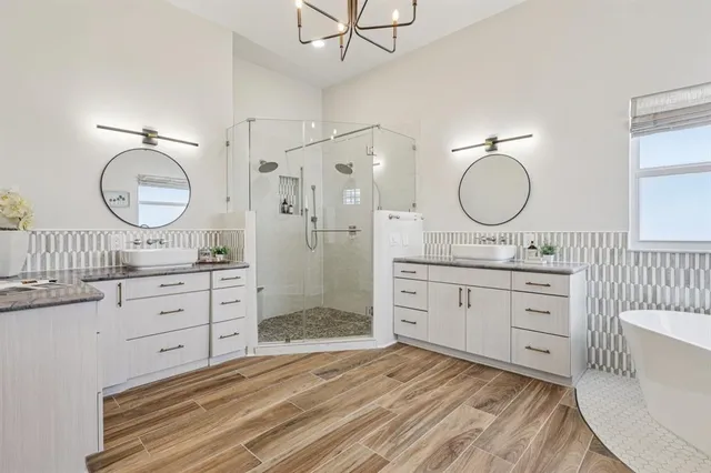 a spacious bathroom with a granite countertop sink mirror and a shower