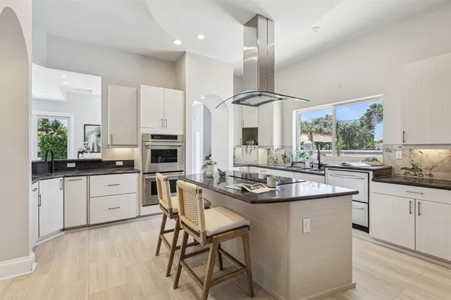 a kitchen with stainless steel appliances kitchen island granite countertop a sink and cabinets
