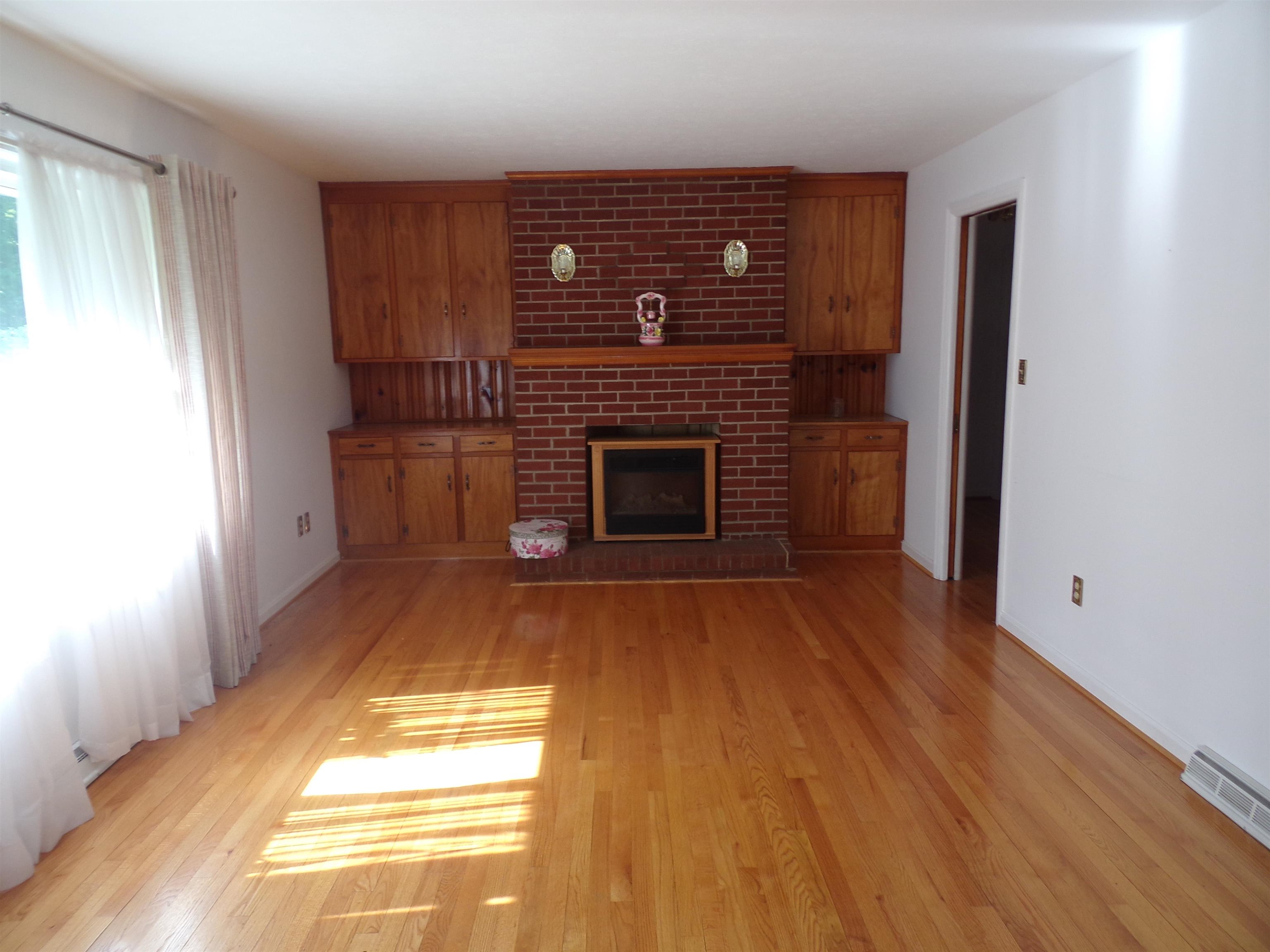 1728 Rockfish Road Waynesboro, VA 22980 - Photo 13 of 42 a view of empty room with wooden floor and fireplace