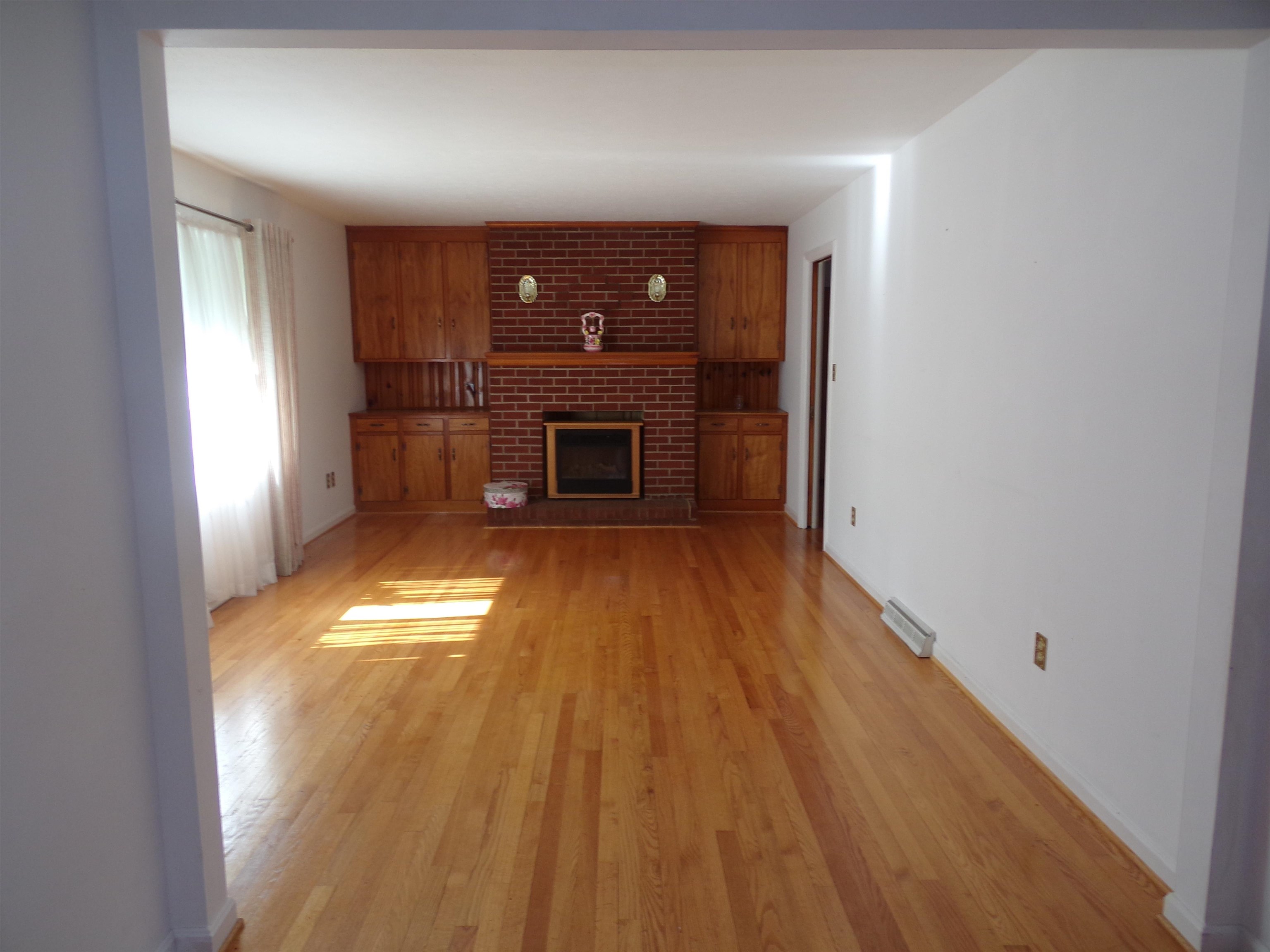 1728 Rockfish Road Waynesboro, VA 22980 - Photo 14 of 42 wooden floor in an empty room with a fireplace