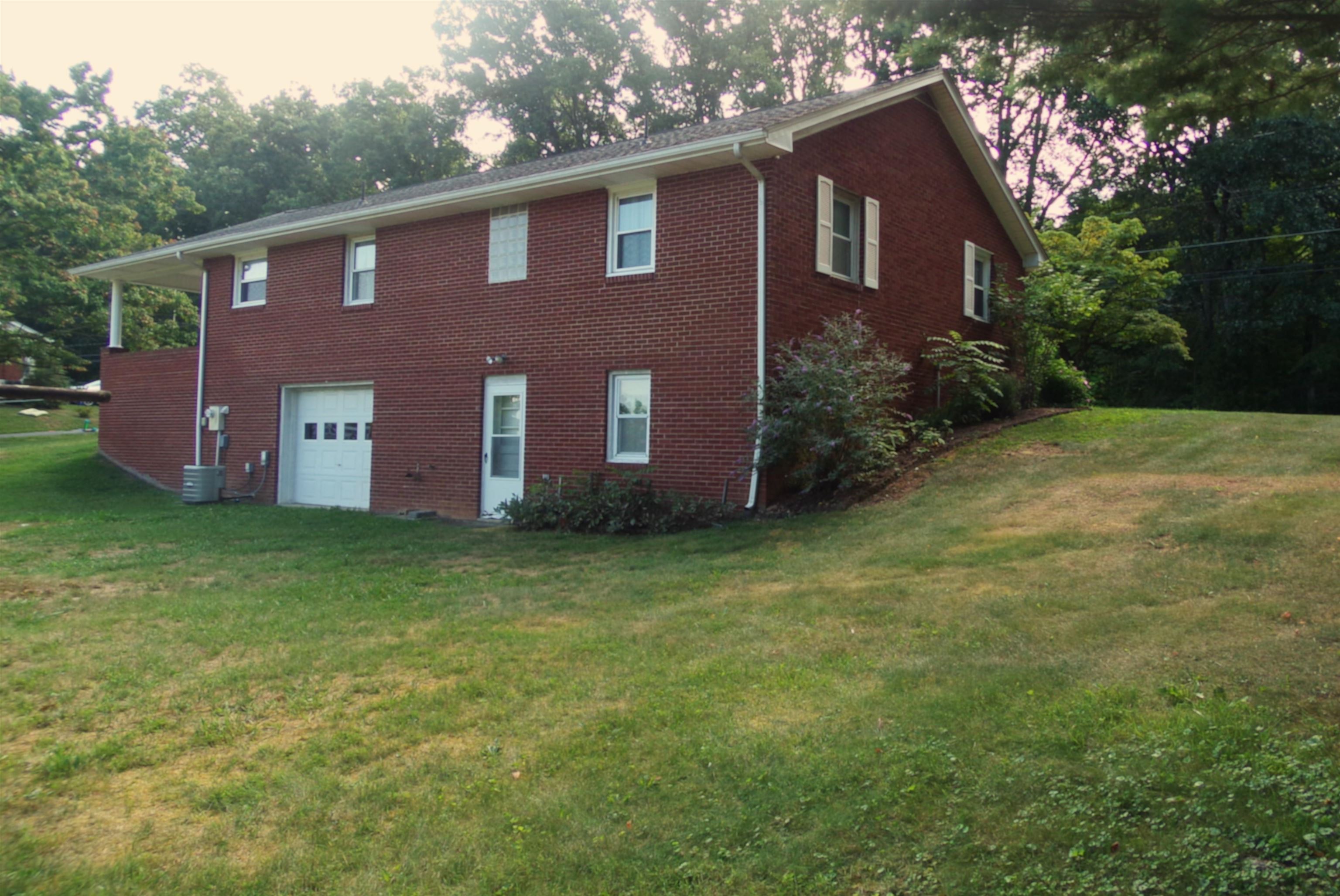 1728 Rockfish Road Waynesboro, VA 22980 - Photo 5 of 42 a brick house with a big yard and large trees