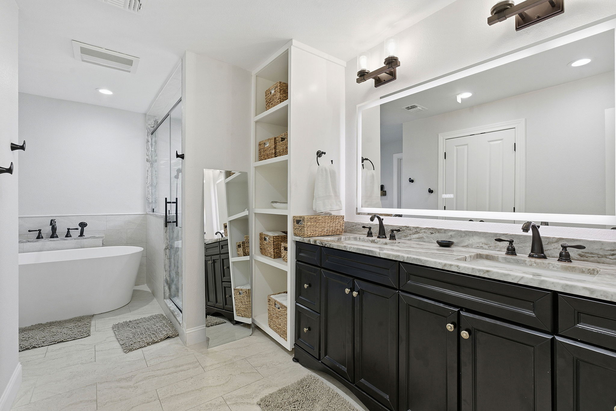 6809 Pioneer Place Austin, TX 78757 - Photo 21 of 33 a spacious bathroom with a double vanity sink a mirror and a bathtub