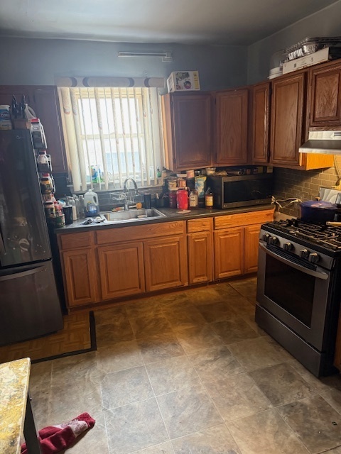 907 South 10th Avenue Maywood, IL 60153 - Photo 7 of 12 a kitchen with granite countertop a stove a sink dishwasher and cabinets