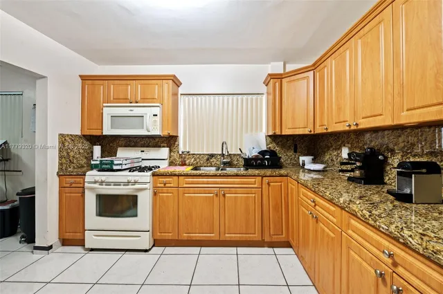 a kitchen with stainless steel appliances granite countertop a stove sink and cabinets