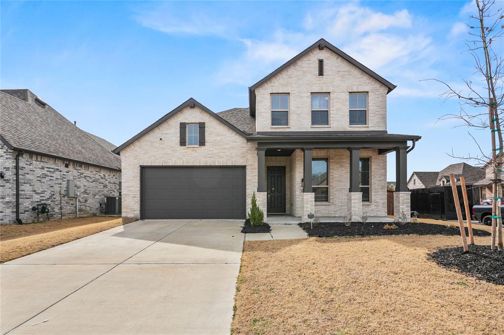 1805 Lockhart Drive Forney, TX 75126 - Photo 1 of 22 View of front of property with covered porch, brick siding, concrete driveway, and a garage
