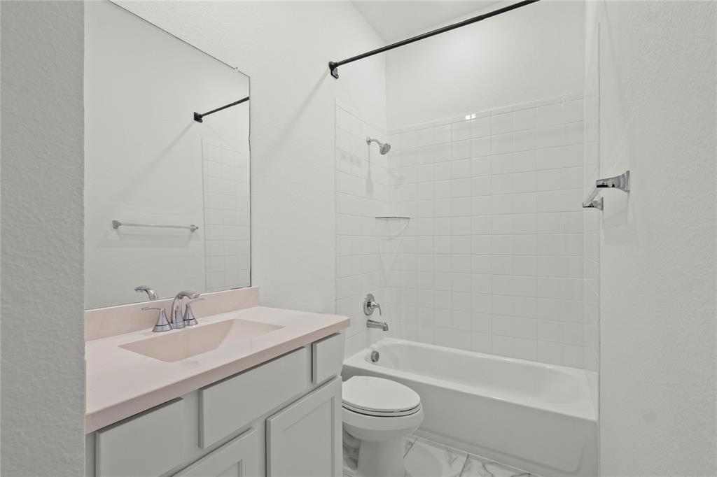 1805 Lockhart Drive Forney, TX 75126 - Photo 12 of 22 Full bath with tub / shower combination, vanity, marble look tiles, and a textured wall