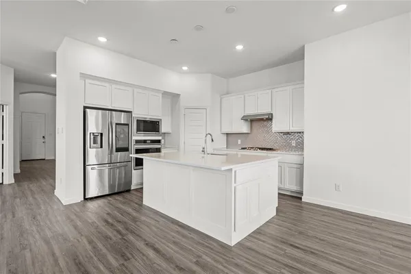 a kitchen with white cabinets and stainless steel appliances