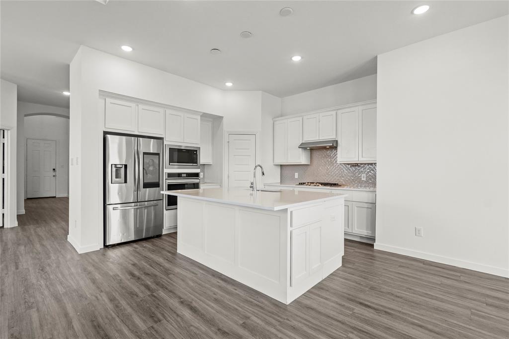 1805 Lockhart Drive Forney, TX 75126 - Photo 4 of 22 Kitchen featuring stainless steel appliances, white cabinetry, arched walkways, recessed lighting, and decorative backsplash