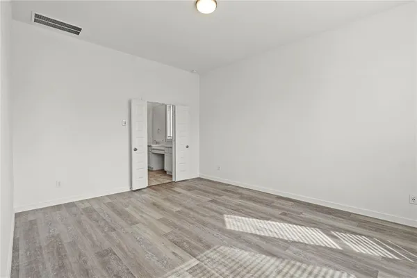 a view of a kitchen with wooden floor electronic appliances and windows