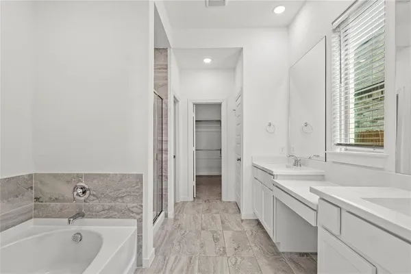 a view of an empty room with wooden floor and cabinets