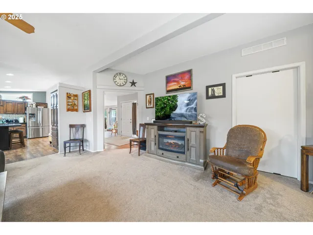 a dining hall view with a large dining table and a large window with wooden floor