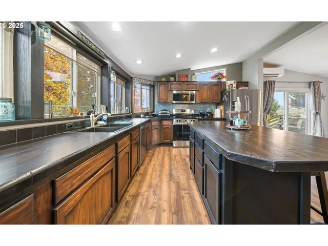a kitchen with kitchen island granite countertop a sink window and cabinets