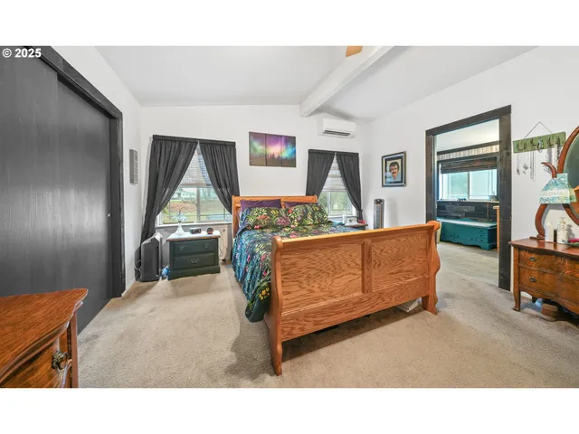 a bedroom with a bed window and mirror