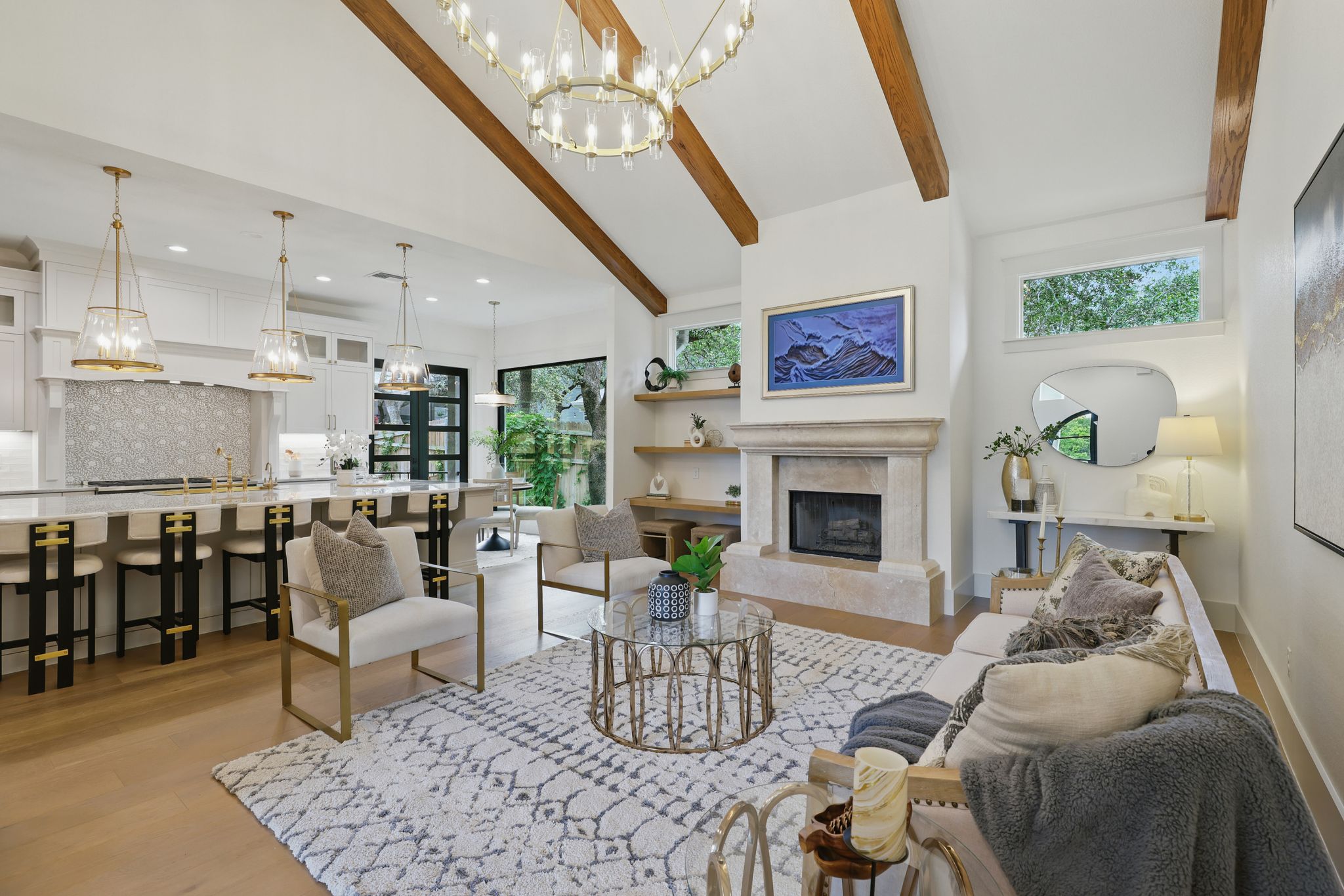 6905 Rudi Cove Austin, TX 78759 - Photo 6 of 37 An open concept living area boasts a fireplace and soaring beamed ceilings, connecting to a sophisticated kitchen.