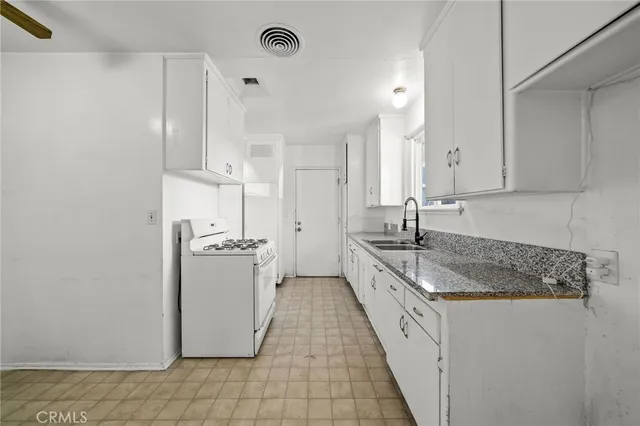 a kitchen with stainless steel appliances granite countertop a sink and a refrigerator