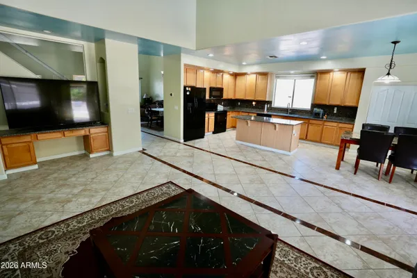 a kitchen with stainless steel appliances kitchen island granite countertop a refrigerator and a stove top oven