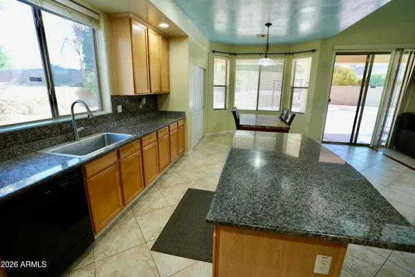 a large kitchen with kitchen island granite countertop a large window